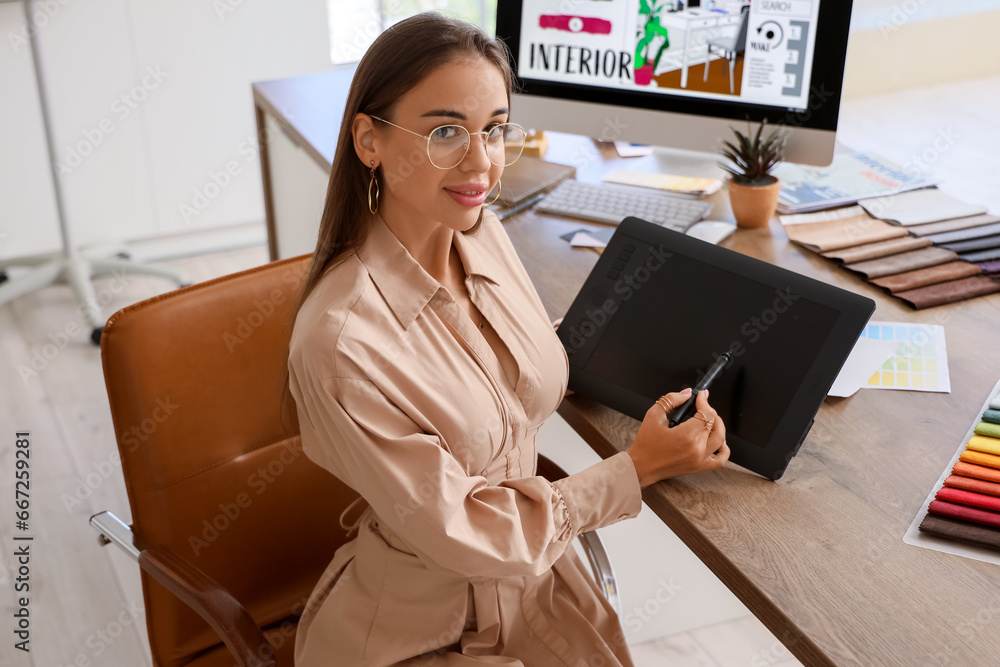 Female interior designer working with graphic tablet at table in office