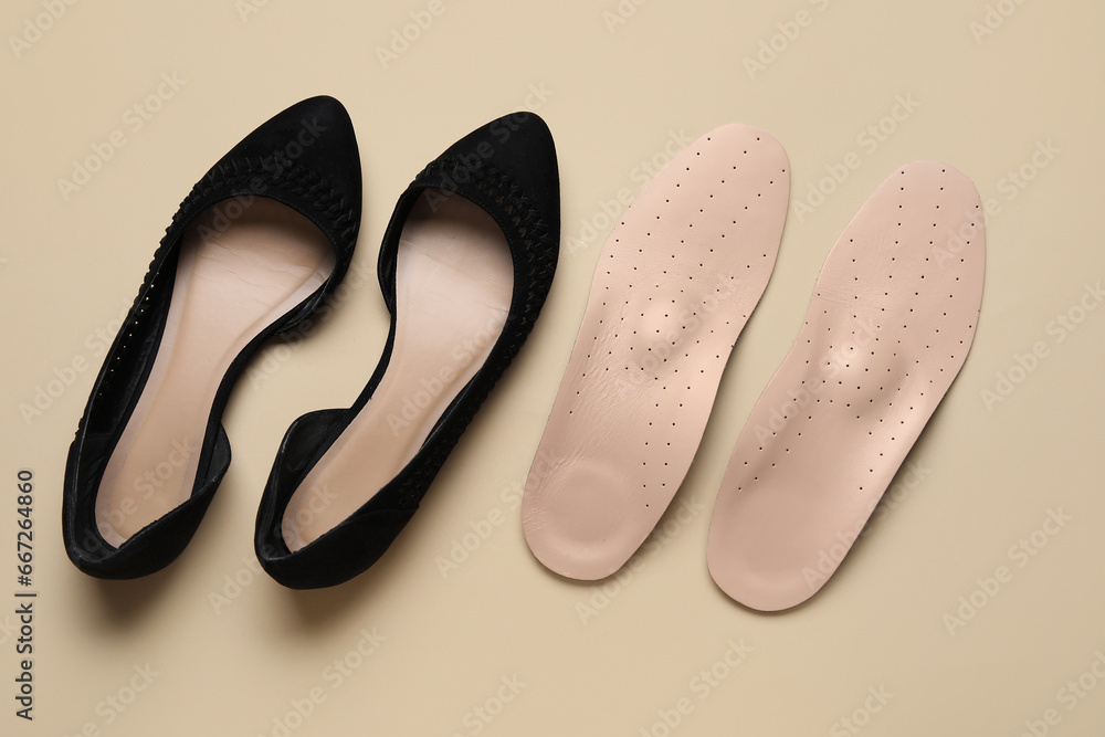 Stylish womens shoes with orthopedic insoles on beige background