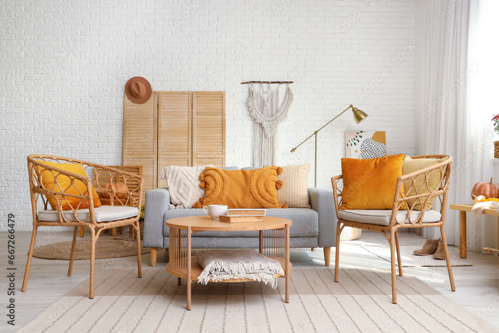 Interior of stylish living room with armchairs, grey sofa and wooden coffee table