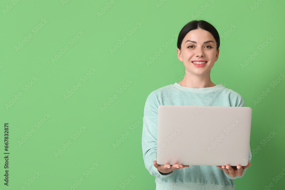 Female programmer with laptop on green background