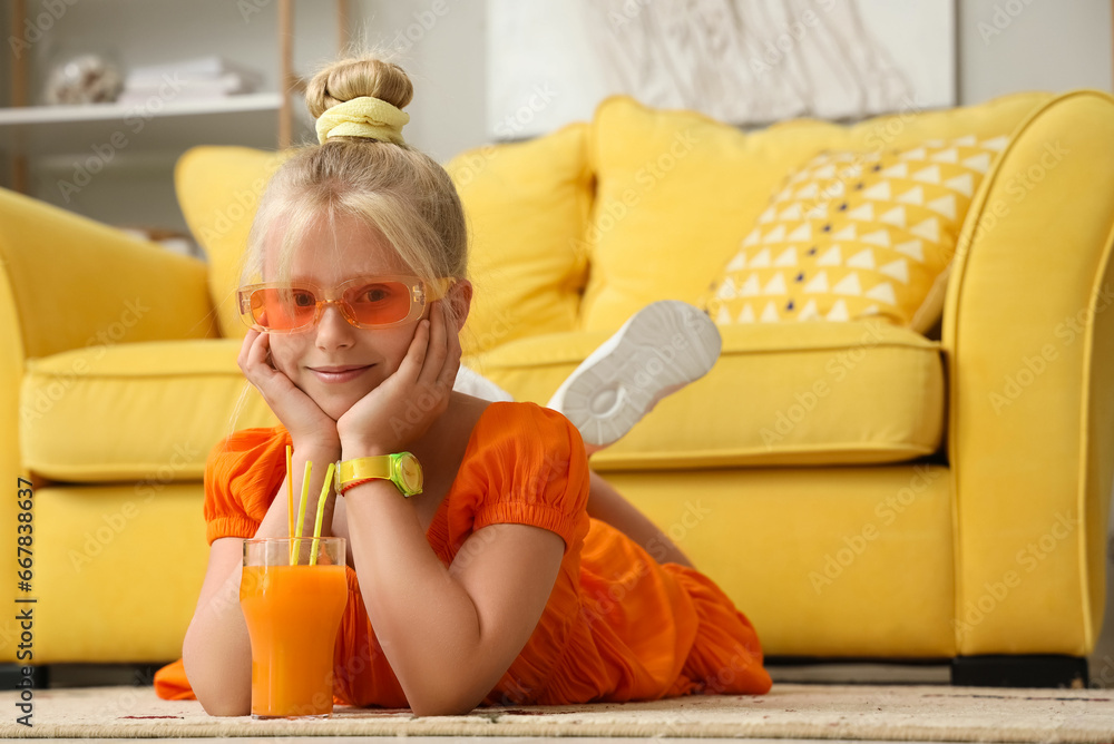 Little girl with glass of juice at home