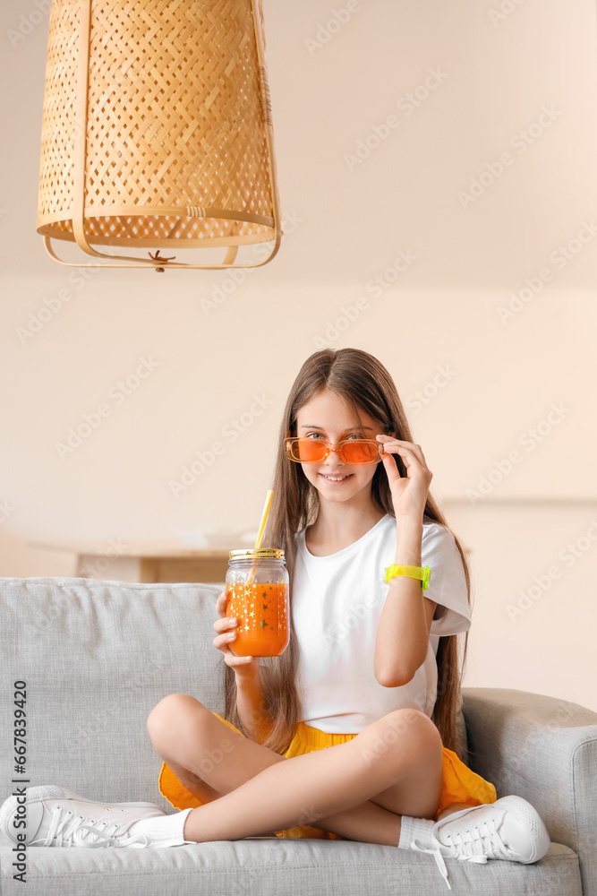 Little girl with glass jar of juice at home