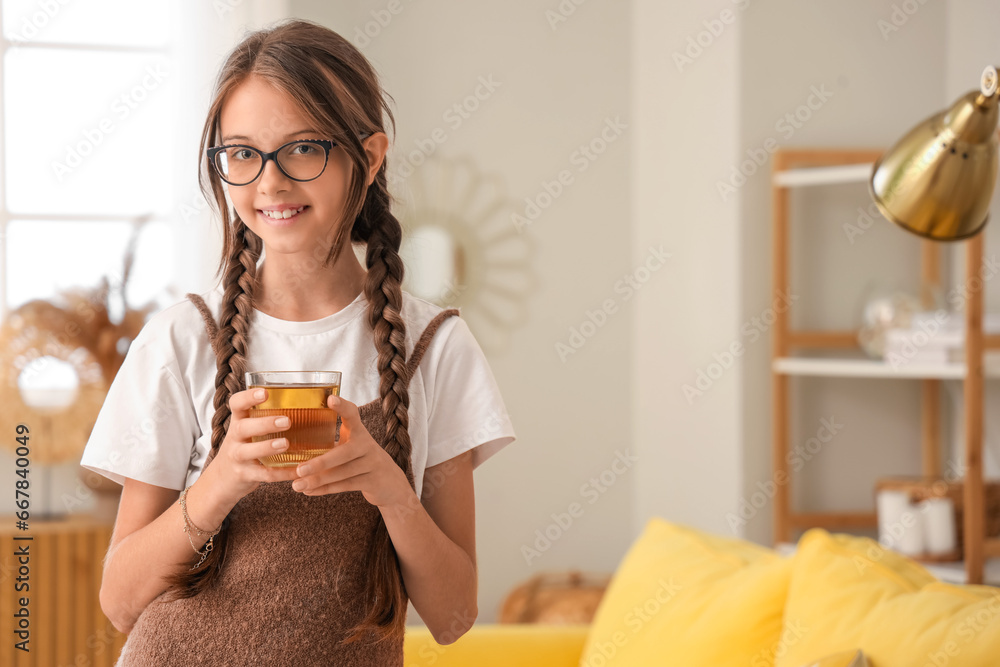 Little girl with glass of juice at home