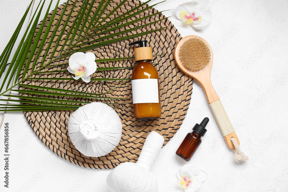 Composition with cosmetic products, spa accessories and palm leaf on light background