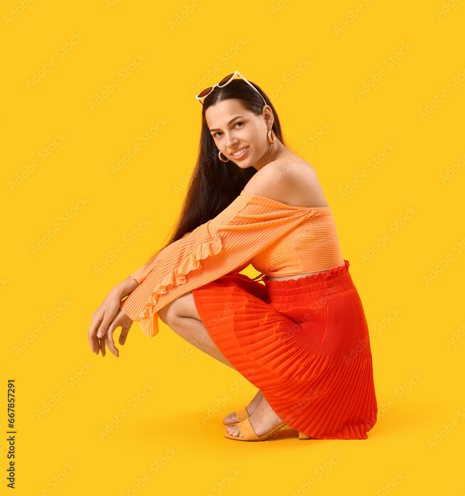 Stylish young woman on yellow background