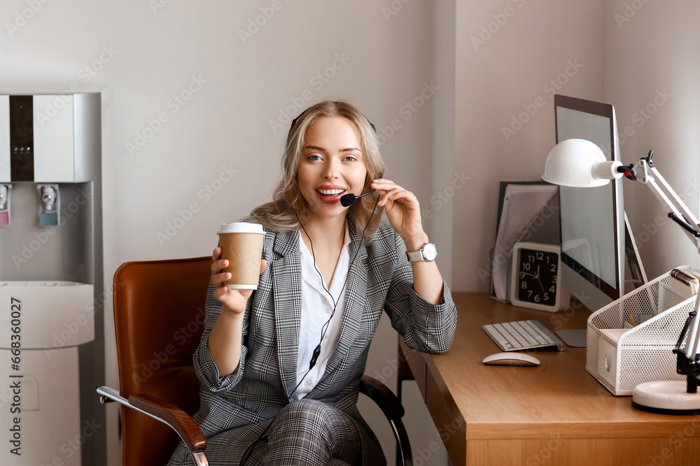 Female technical support agent with coffee working in office