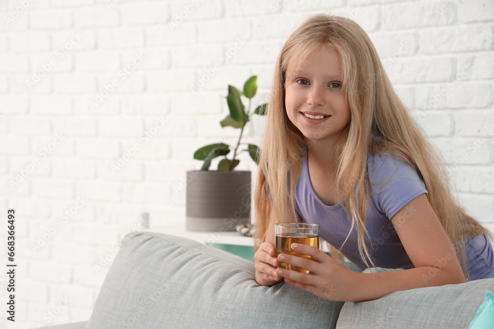 Little girl with glass of juice at home