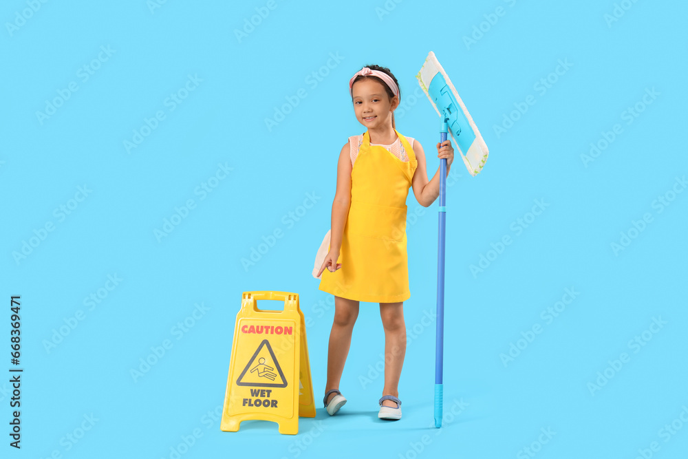 Cute little janitor with mop and caution sign on blue background