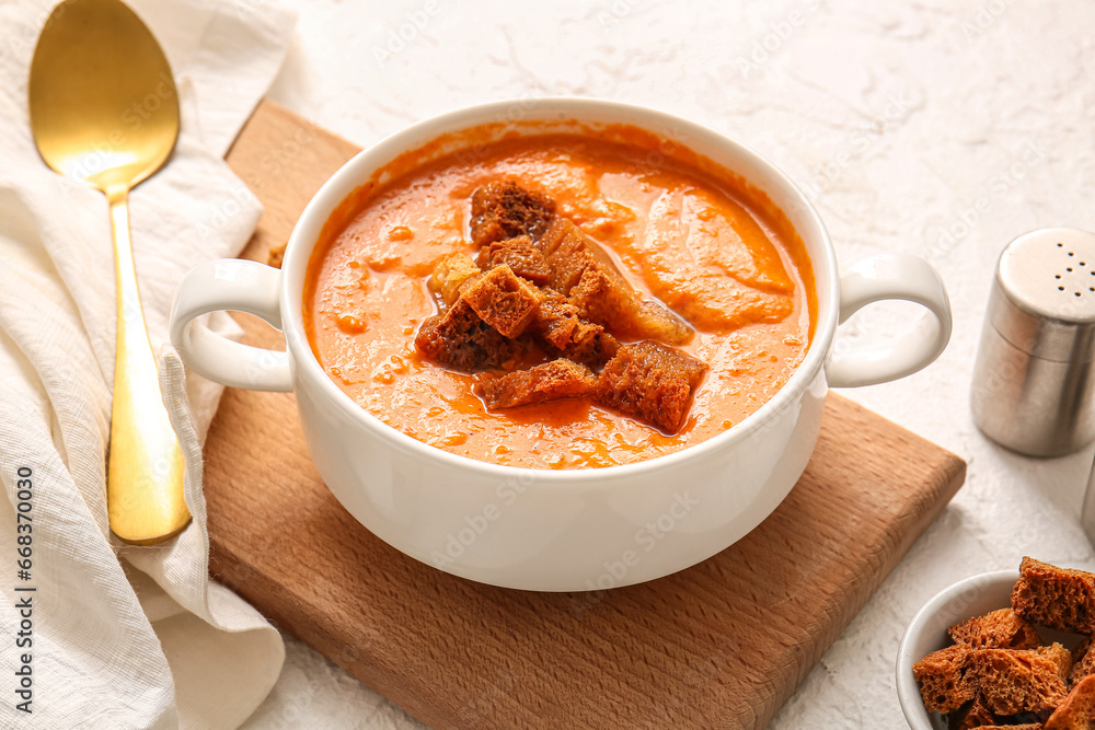 Pot of tasty cream soup with croutons on white background