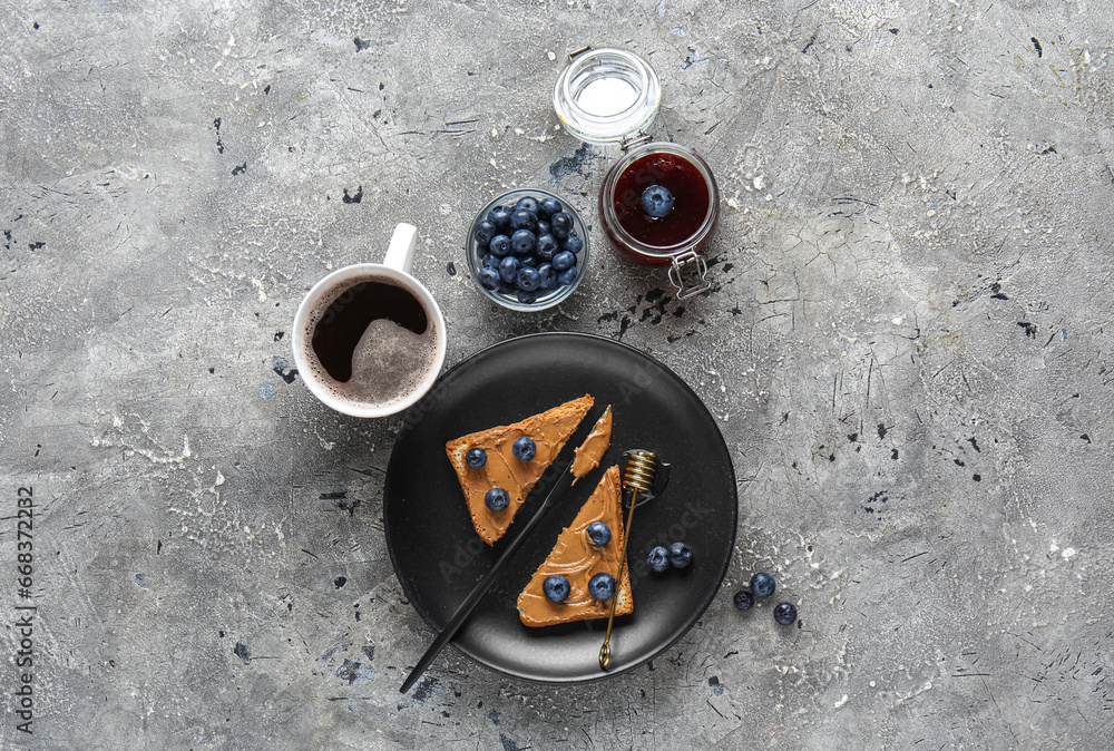 Plate of cut toast with peanut butter and blueberries on grey background