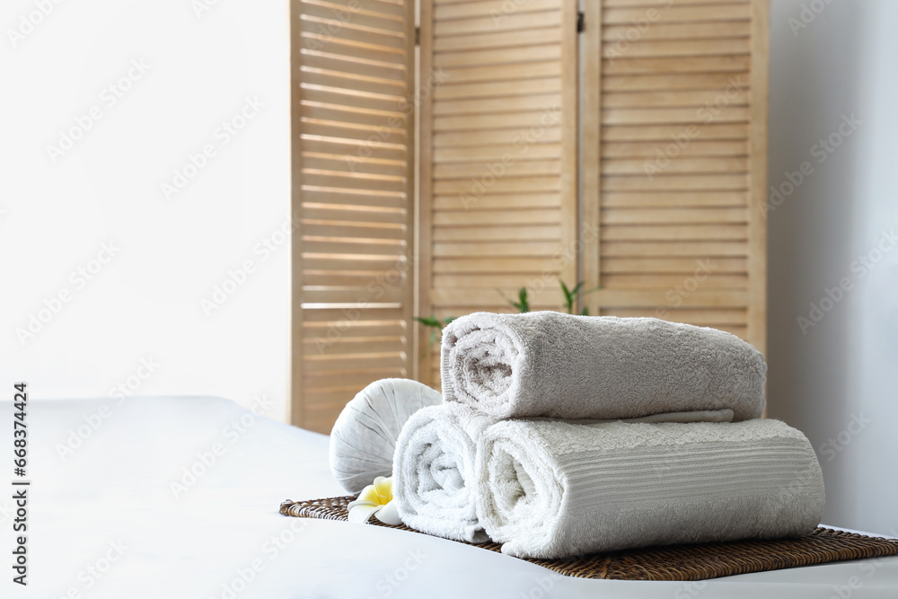 Towels with flower on couch in spa salon, closeup