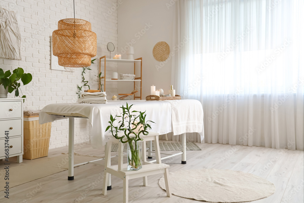 Interior of spa salon with couch and burning candles