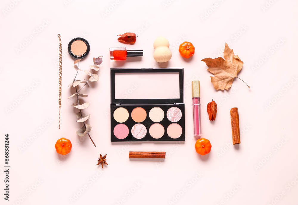 Composition with cosmetic products and autumn decor on pink background