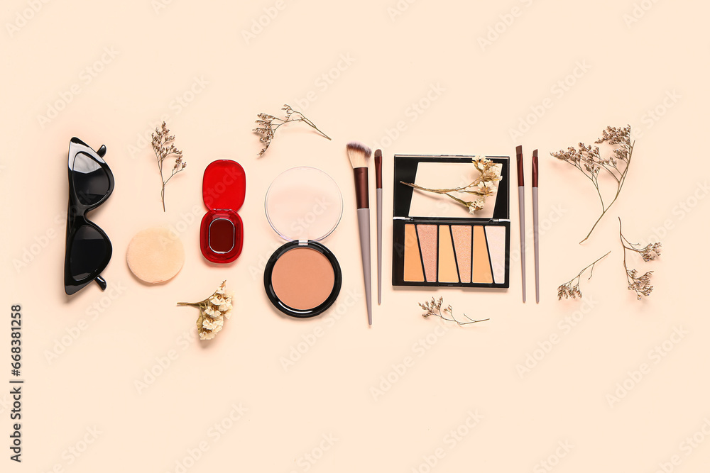 Composition with makeup products, accessories and dry twigs on beige background