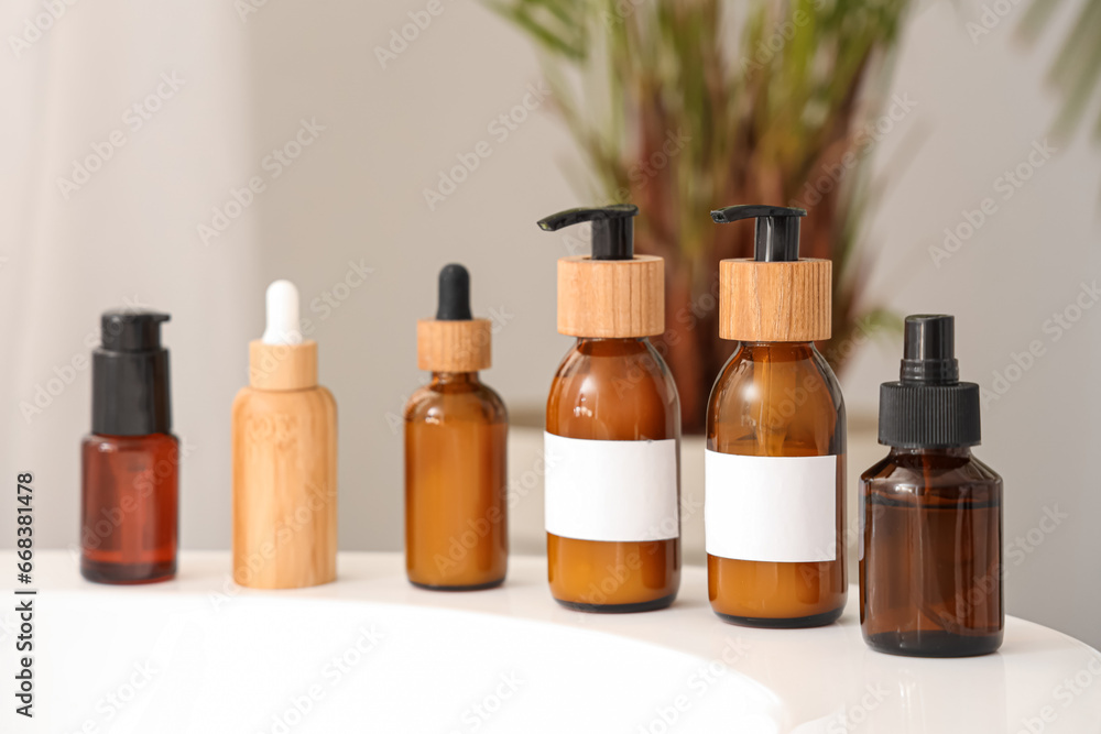 Bottles of cosmetic products on bathtub in room, closeup