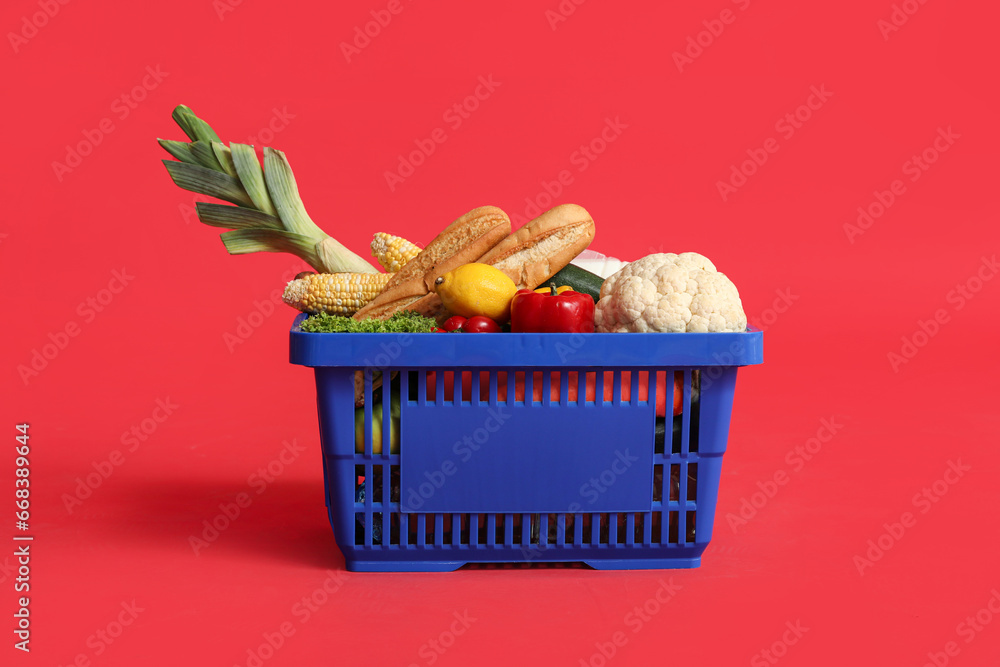 Shopping basket full of food on red background