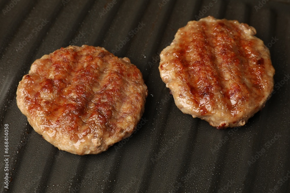 Tasty hamburger patties on grill pan, closeup