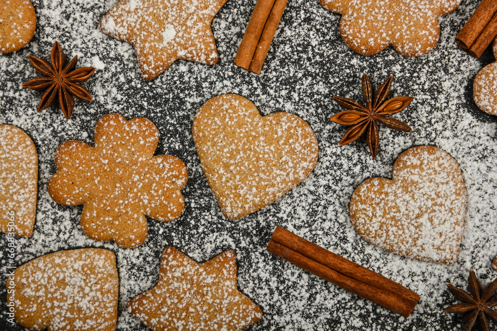 Gingerbread cookies and spices on black slate