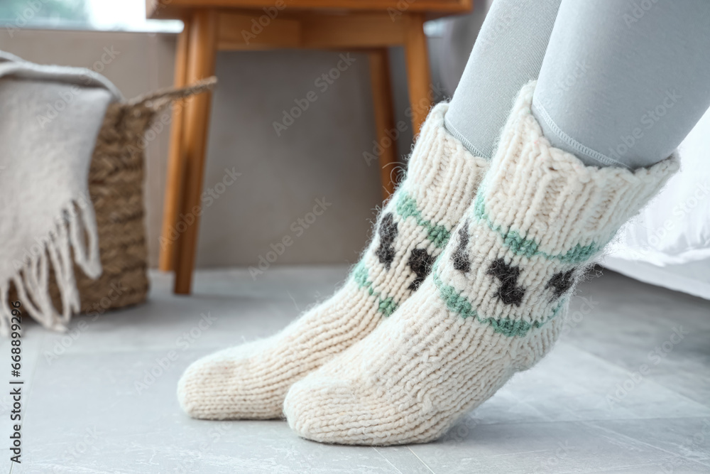 Woman in warm socks on floor with heating at home, closeup