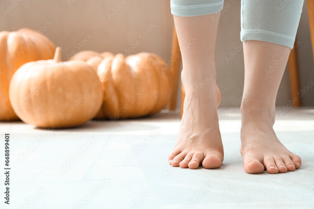 Barefoot woman on floor with heating in bedroom, closeup