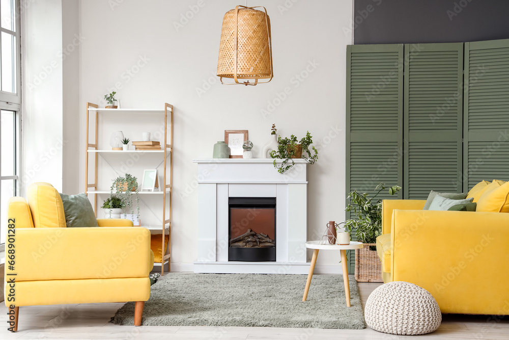 Interior of living room with electric fireplace, shelf unit and houseplants