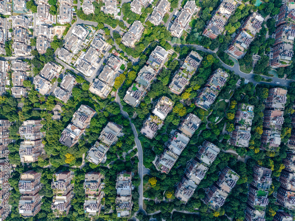 Aerial photography of a green city with many plants and ventilation equipment on the roof and an air conditioner outdoor unit at work