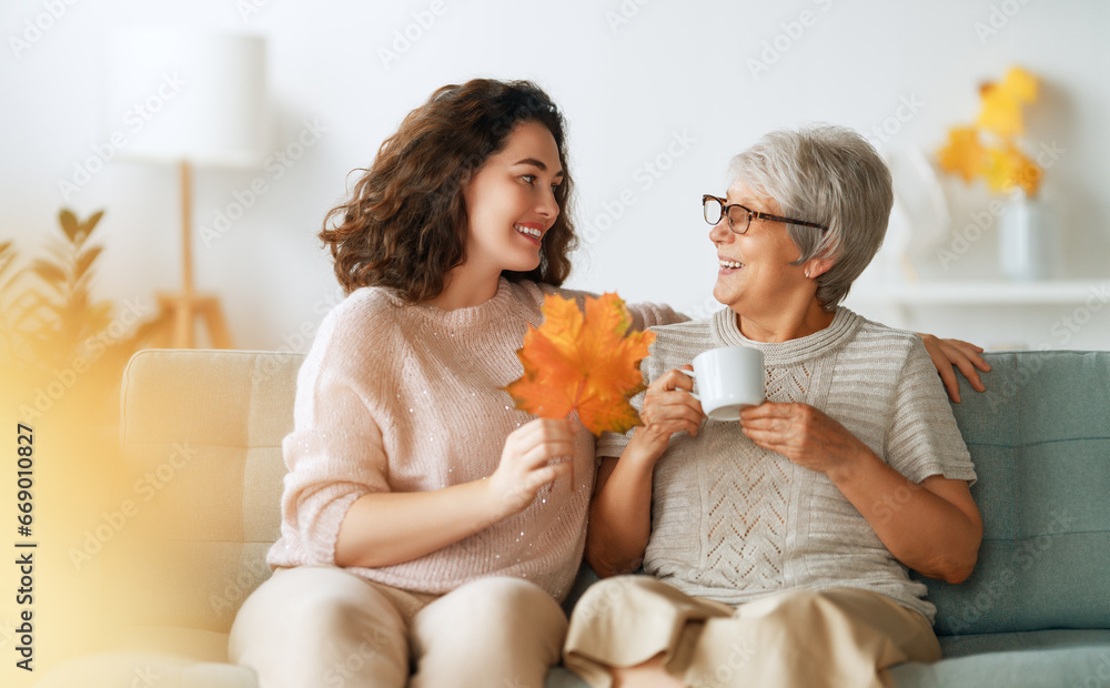 woman and her senior mother with autumn leaves