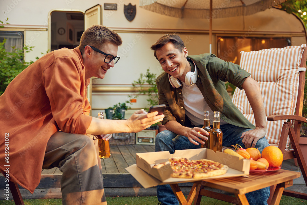 Male friends having outdoors camping party together