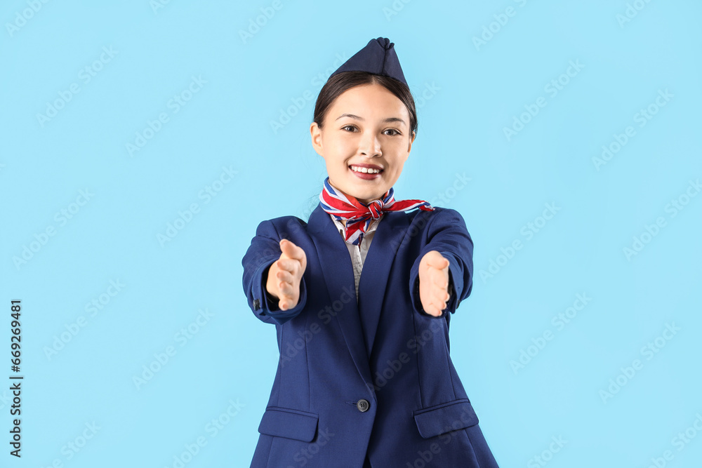 Beautiful Asian stewardess on blue background