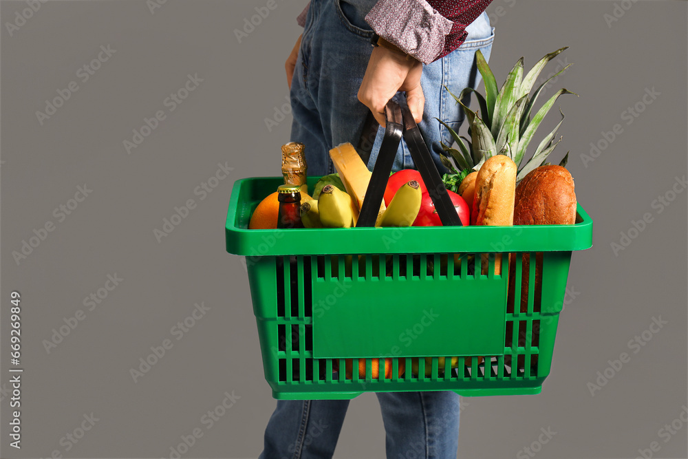 Man with shopping basket on grey background