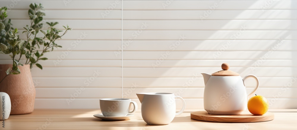 Ceramic teapot and cup on a table in a light kitchen with classic interior and soft lighting