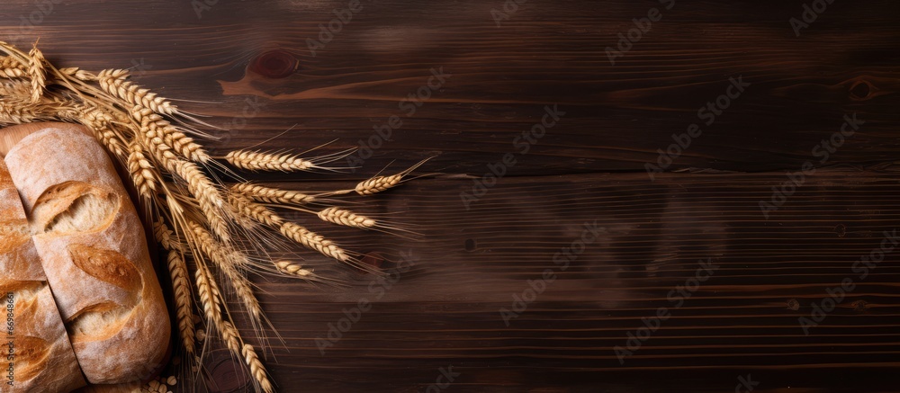 Top view of artisan bread with wheat ears wooden backdrop