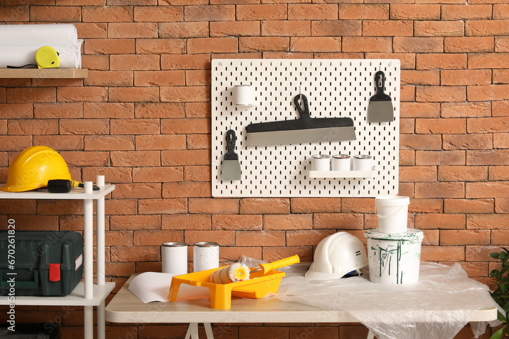 Pegboard with trowels and paint cans in workshop