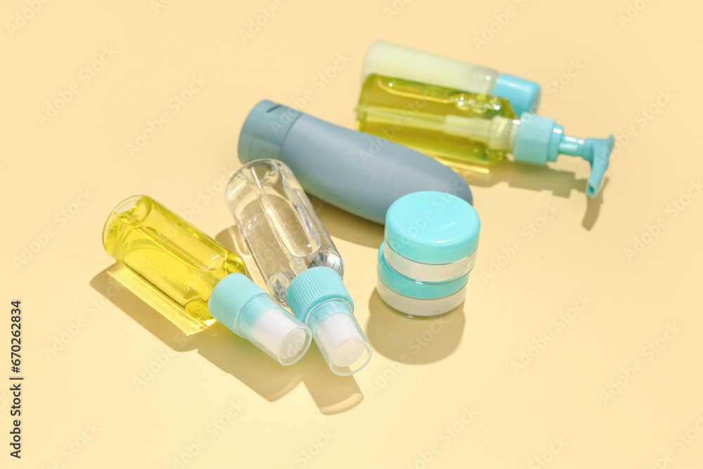 Set of travel cosmetic products on yellow background