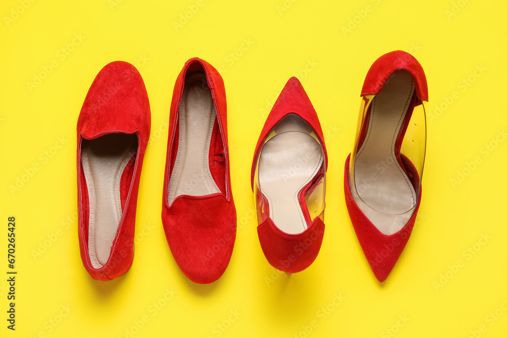 Different stylish red shoes on yellow background