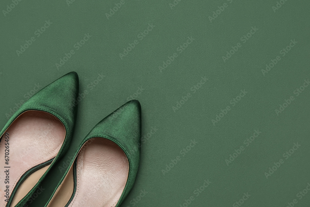 Stylish green high heels on color background