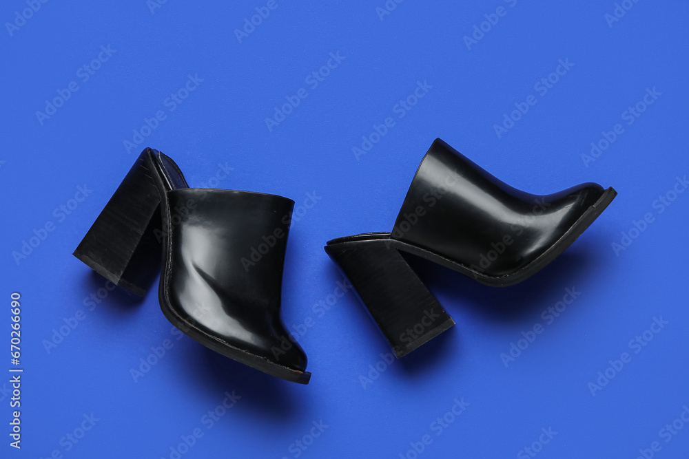 Stylish black shoes on blue background