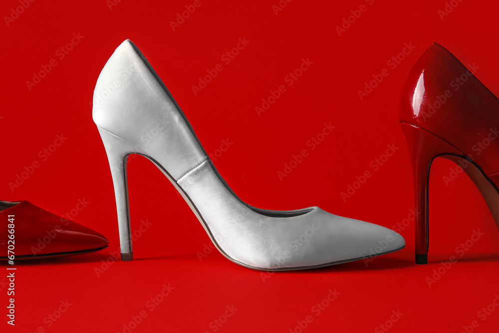 Different stylish high heels on red background