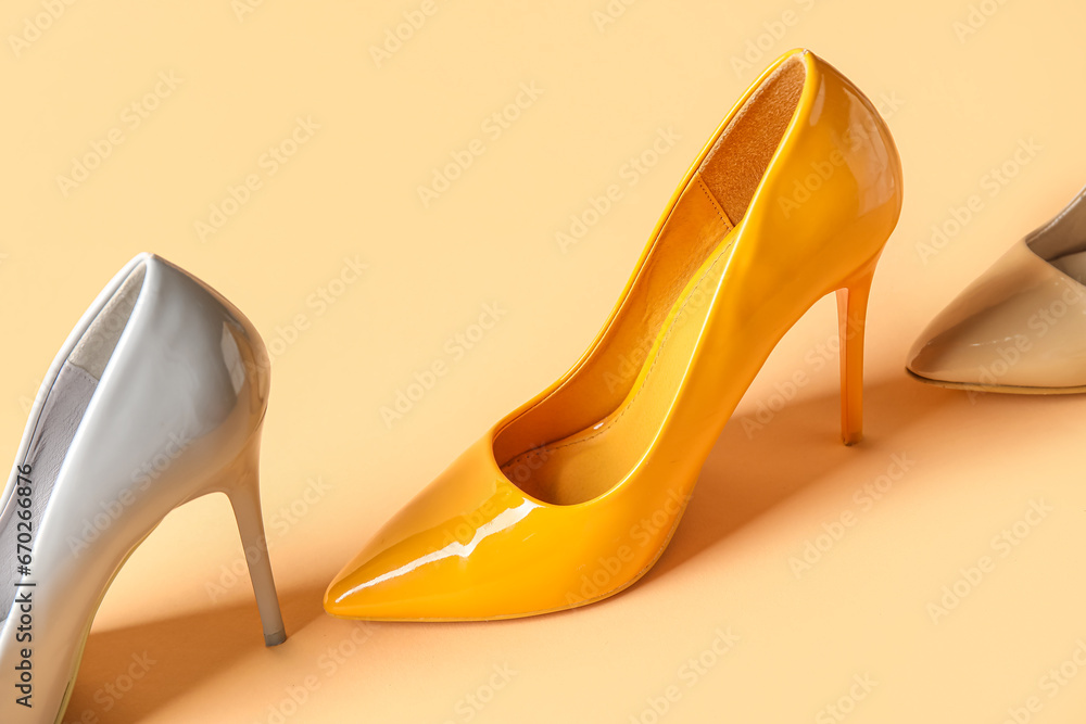 Different stylish high heels on yellow background