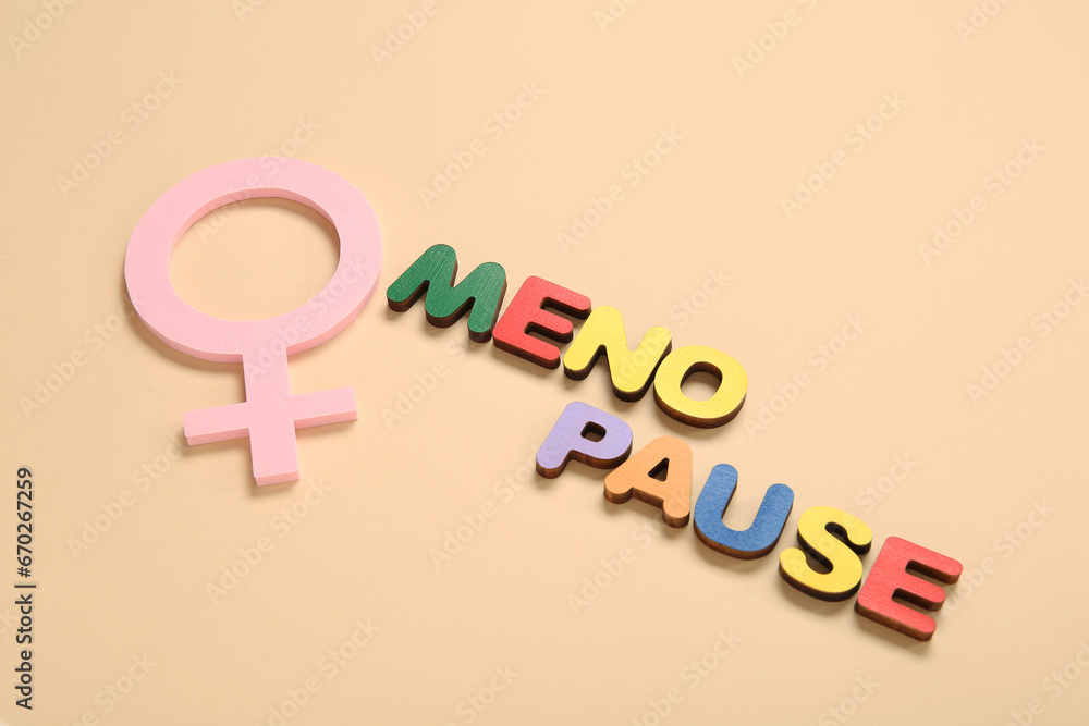 Word MENOPAUSE with symbol of woman on beige background