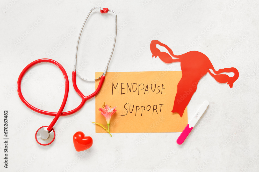 Paper with text MENOPAUSE SUPPORT, uterus, pregnancy test and stethoscope on white background