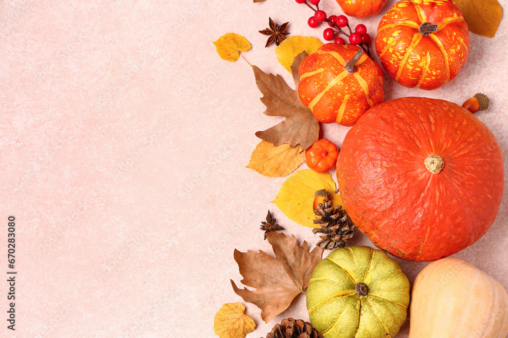 Autumn composition with ripe pumpkins, berries, spices and fallen leaves on light background