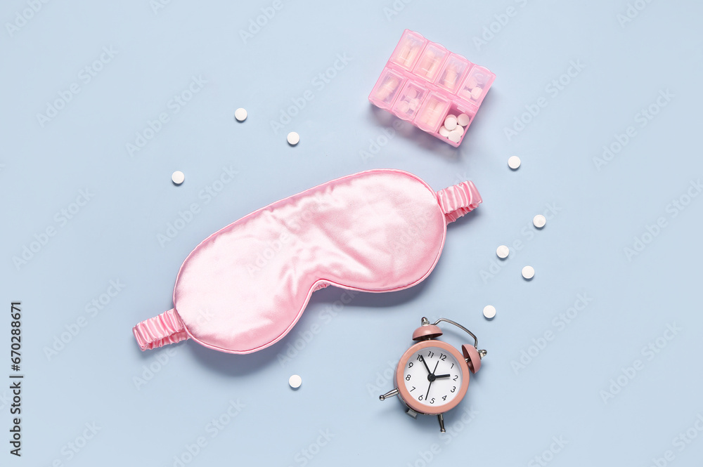 Composition with sleep mask, alarm clock and pills box on color background