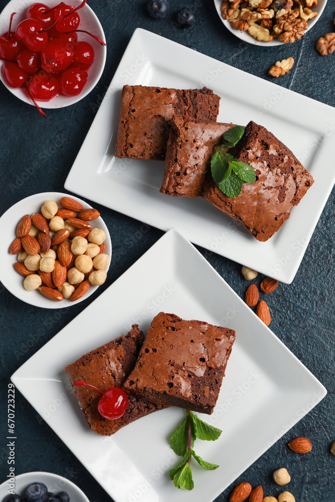 Plates with pieces of tasty chocolate brownie on black background