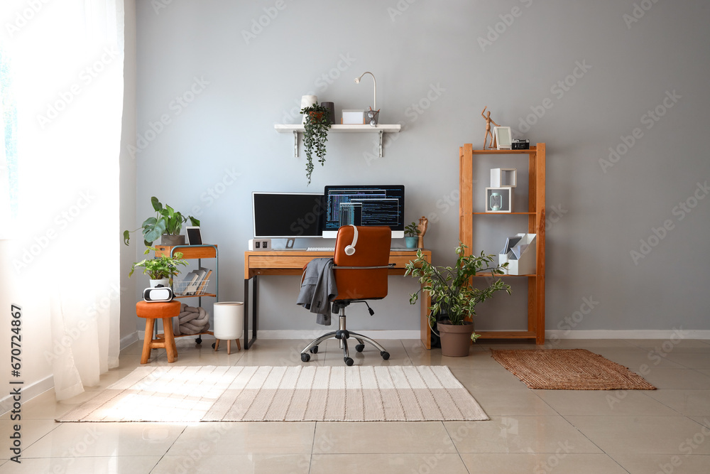 Interior of light office with programmers workplace and houseplants