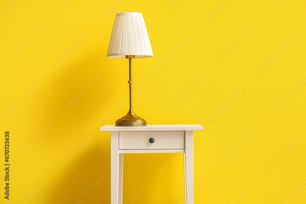 End table with lamp near yellow wall