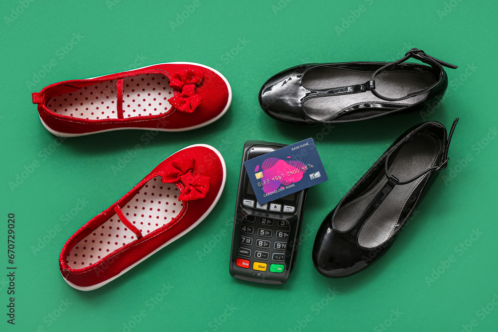 Stylish childs shoes, payment terminal and credit card on green background