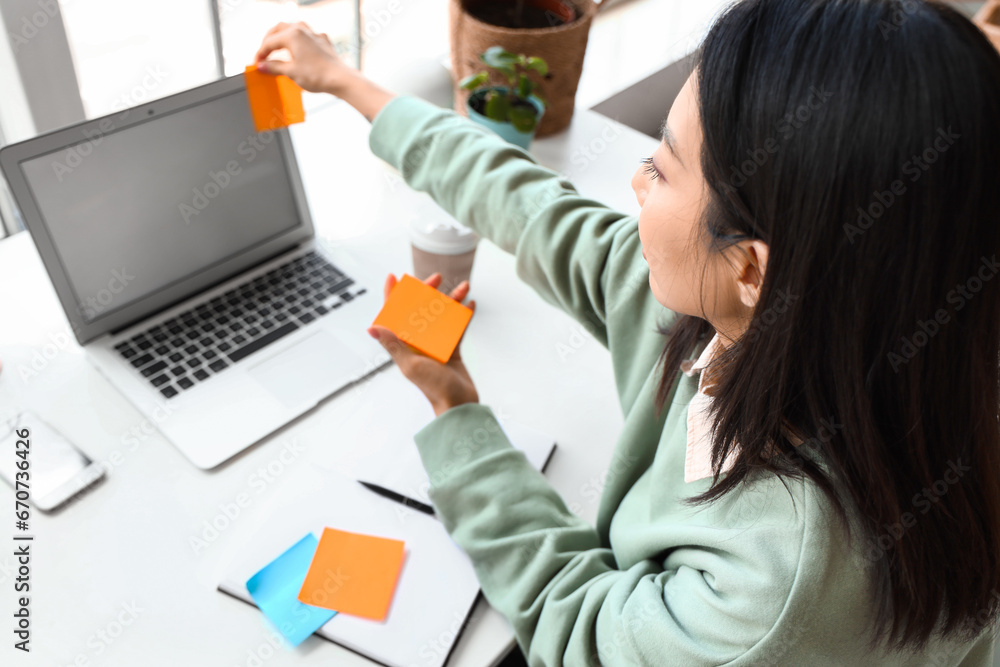 Young Asian woman working with laptop at home office