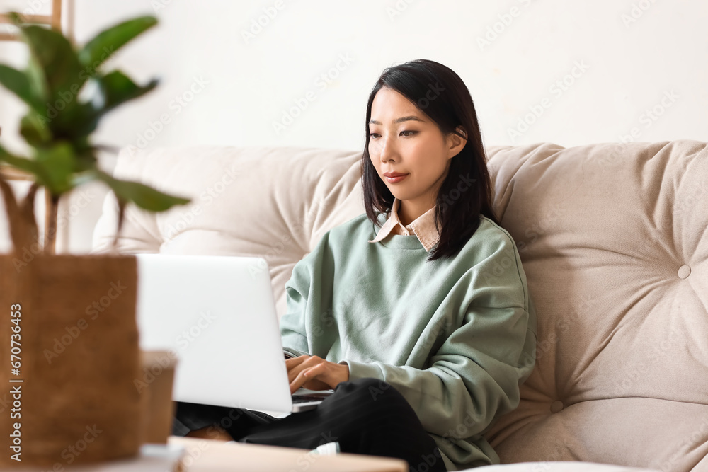 Young Asian woman working with laptop at home