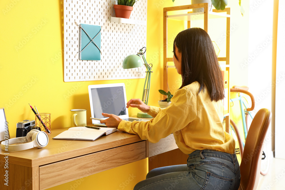 Young Asian woman working with laptop at home office